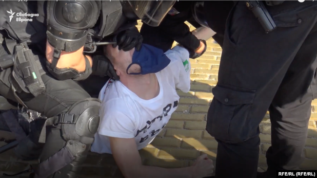 Няколко полицаи притискат Даниел Павлов към земята и едновременно с това извиват главата му нагоре