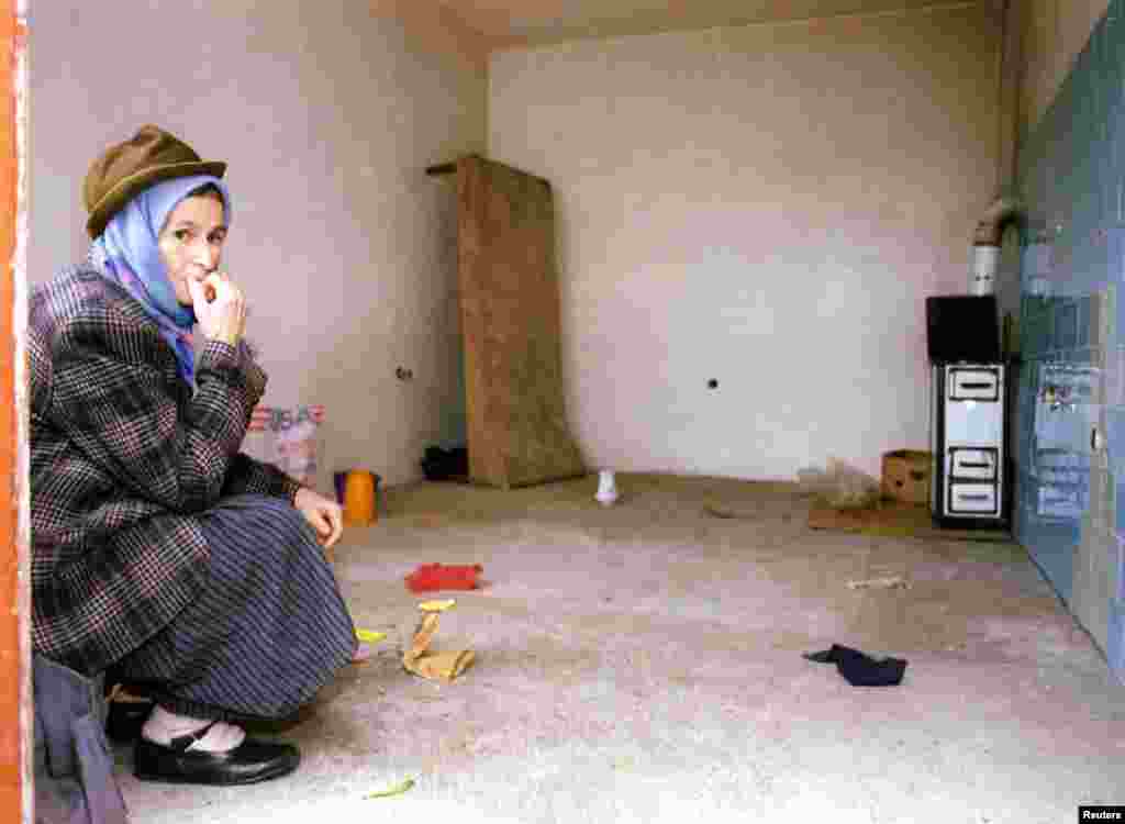 A Bosnian Serb woman sits in her empty house as she prepares to leave the northern Bosnian town of Odzak on December 11, 1995. She was among 19,000 Bosnian Serbs that were relocated as the town came under Bosnian government control under the Dayton peace agreement.