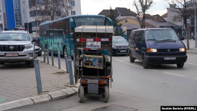 Një karrocë që kalon në mes të veturave në Prishtinë, për shkak të lartësisë së trotuareve.