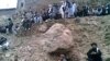 A video grab shows people watching the execution by gunfire of a 22 year old woman named as Najiba (not pictured) in Qol village, Parwan province.