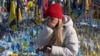 A woman cries at the memorial to the fallen Ukrainian soldiers on Independence Square in Kyiv on February 24.