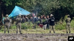 Grănicier polonezi blocând un grup de migranți la granița cu Belarus
