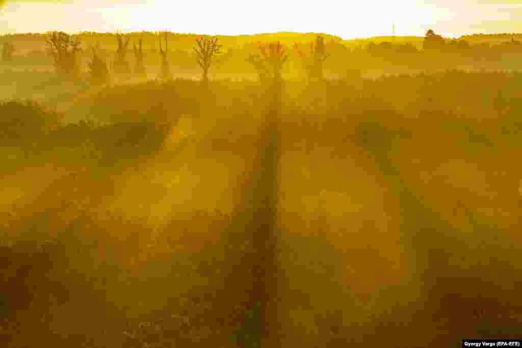 The landscape is seen behind a veil of fog at sunrise in Nagykanizsa, Hungary.