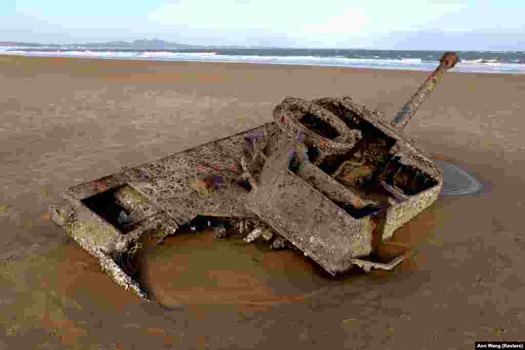 Félig elsüllyedt tank a tengerparti homokban Csinmen partjainál