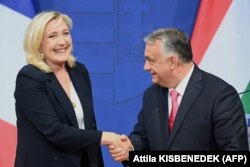 Marine Le Pen, a francia szélsőjobboldali Rassemblement National (RN) párt vezetője és a francia elnökválasztás jelöltje (balra) kezet fog Orbán Viktor magyar miniszterelnökkel a miniszterelnöki hivatalban, a budai Várnegyed Karmelita kolostorában Budapesten 2021. október 26-án tartott sajtótájékoztatón