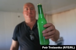 Фермер Анатолий Горбачев держит в руках бутылку кумыса. Село Чеботарево, Западно-Казахстанская область. 28 августа 2021 года