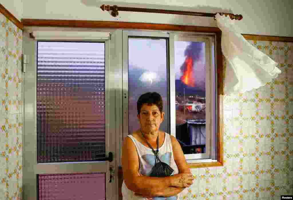 61-річна Марія Хесус стоїть перед вікном свого будинку в Ель-Пасо, з якого видно, як тече лава з вулкану Кумбре-В&#39;єха. Ла-Пальма, Іспанія, 4 жовтня 2021 року. &laquo;Я відчуваю страх, жах, іноді агонію, бачачи людей, які страждають і залишилися ні з чим&raquo;, &ndash; сказала Хесус агенству Reuters &nbsp;
