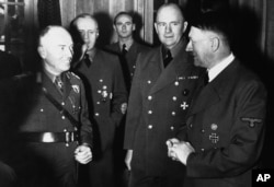 Адольф Гітлер (справа) і прэм'ер-міністар Румыніі маршал Іён Антанеску ў сваёй штаб-кватэры падчас перамоваў, 16 студзеня 1943 года. У цэнтры справа міністар замежных спраў Германіі Ёахім фон Рыбентроп.