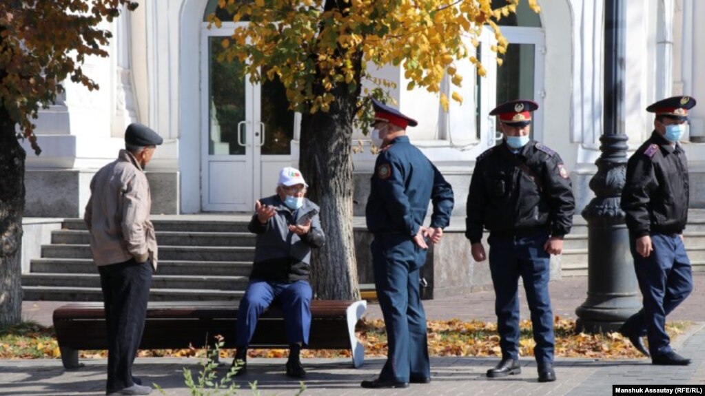 Полицейские задают вопросы прохожим у предполагаемого места проведения митинга сторонников оппозиции. 23 октября 2021 года