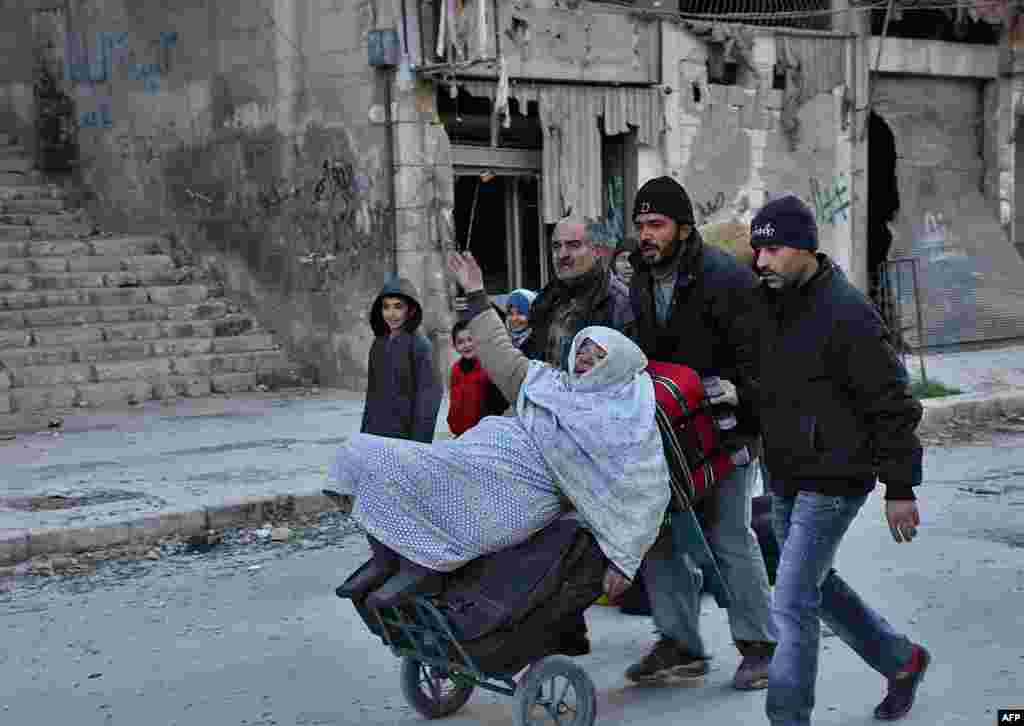 Syrian residents fleeing the violence in the eastern rebel-held parts of Aleppo evacuate from their neighborhoods through the Bab al-Hadid district after it was seized by the government forces on December 7. (AFP/George Ourfalian)