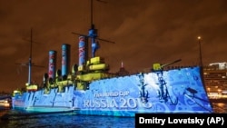 Крейсер "Аврора" в Санкт-Петербурге, давший сигнал к перевороту в 1917 году. На него спроецирован логотип чемпионата мира по футболу 2018 года
