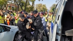 Үкіметке наразылық шеруіне шыққан адамды көшеден әкетіп бара жатқан полицияны сурет пен видеоға түсіріп тұрған журналистер. Алматы, 21 қыркүйек 2019 жыл.