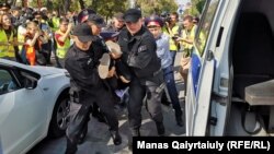 Полицейские задерживают участника акции протеста в Алматы. 21 сентября 2019 года.
