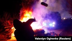 Nowi Sanžary şäherinde protestçi polisiýanyň ulagyna daş zyňýar. 20-nji fewral, 2020 ý.