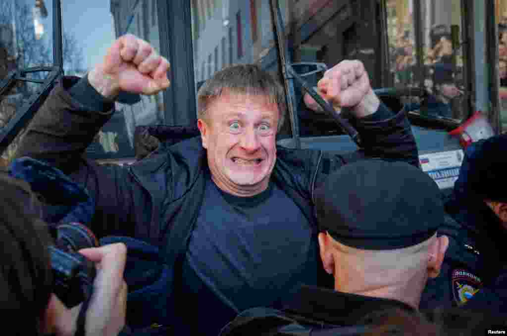 An opposition supporter blocks a police van transporting detained anticorruption campaigner and opposition figure Aleksei Navalny during a rally in Moscow on March 26. (Reuters/Maksim Shemetov)