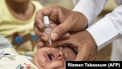 A Pakistani health worker administers polio drops to a child during a vaccination campaign in Karachi in June.