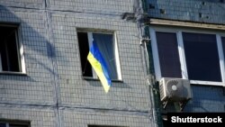 Украинский флаг в одном из окон многоэтажного дома. Иллюстративное фото