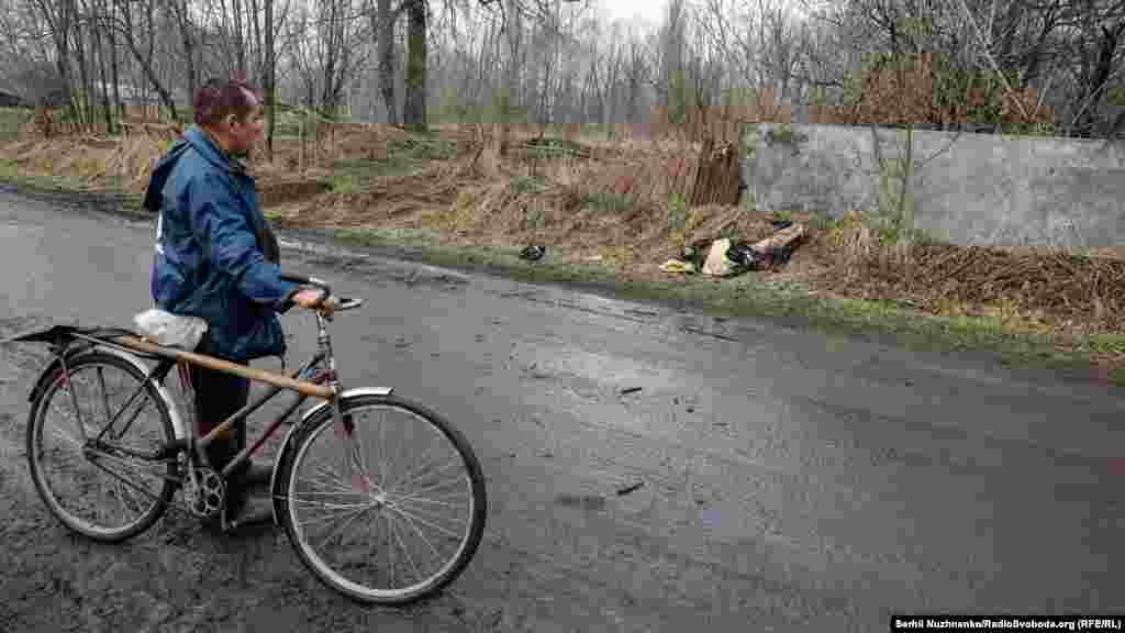 A villager looks at the body of a dead Russian soldier.