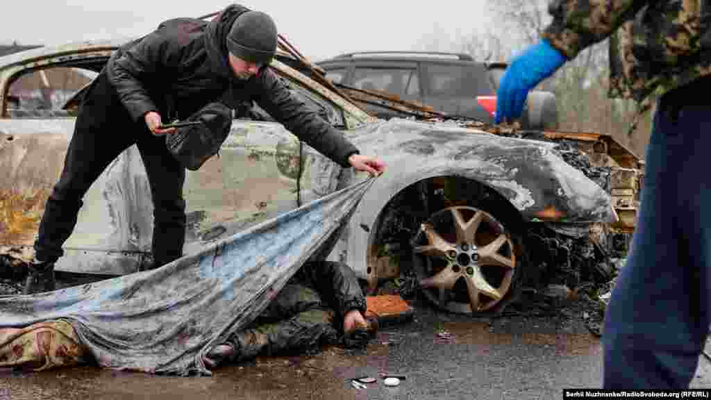 A forensics expert documents the scene where a civilian was killed.