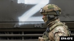 Российский военнослужащий на фоне грузовика с символом полномасштабного вторжения России в Украину. Иллюстрационное фото
