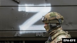 Российский военнослужащий на фоне армейской техники с символом Z. Иллюстрационное фото