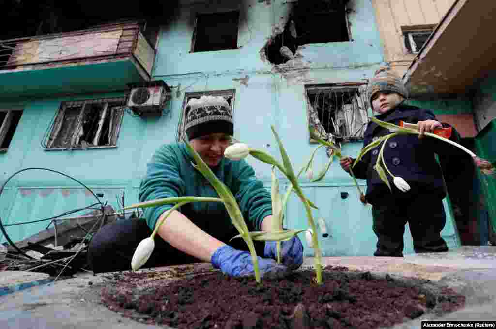 A 33 éves Viktoria Mukina tulipánt ültet lányával, Miroszlavával Mariupolban 2022. április 4-én