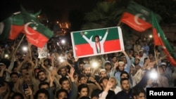 Supporters of Imran Khan's Tehrik-e Insaf (PTI) party wave flags and chant in support of the former prime minister at a rally in Peshawar on April 10.