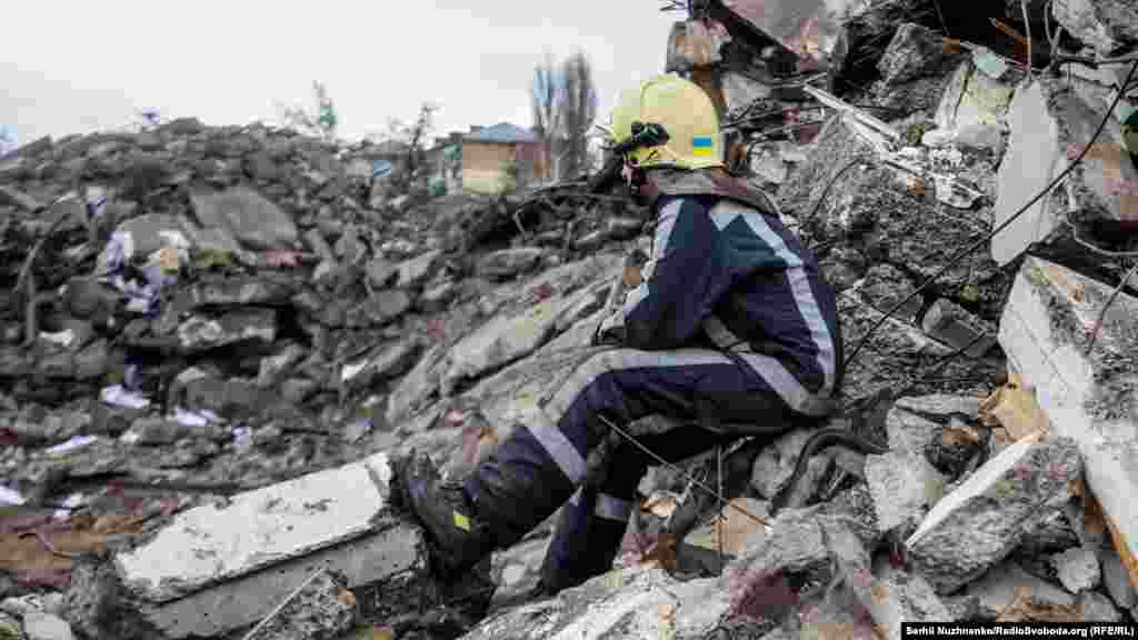 Рятувальник оглядає фотоальбом, знайдений серед залишків житлового будинку, зруйнованого під час вторгнення Росії в Україну. Бородянка, Київська область, Україна, 8 квітня 2022 року