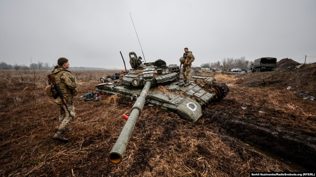 Ushtarët ukrainas inspektojnë një tank rus të braktisur që ka ngecur në baltë.