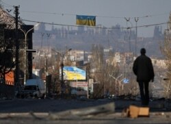 Un bărbat din Mariupol merge singur pe o stradă afectată de război, 7 aprilie 2022.