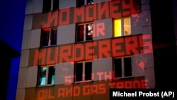 Слова «Ні грошам для вбивць! Зупиніть торгівлю нафтою та газом!» активісти спроєктували на консульство Росії у Франкфурті, Німеччина, 4 квітня 2022 року