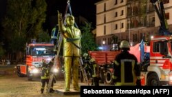 GERMANY -- Fireworkers lift a four-metre tall golden statue featuring Turkish President Recep Tayyip Erdogan to remove it, in the western German town of Wiesbaden, August 28, 2018