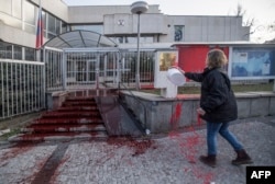 An activist pours red paint on the stairs of the Russian Embassy in Prague on March 26.