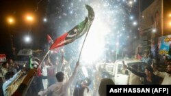 People celebrate on the streets of Karachi following the Supreme Court's April 7 ruling, which overturned Prime Minister Imran Khan's move to block a no-confidence vote and dissolve the parliament.