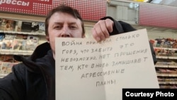 Артур Дмитриев с плакатом с антивоенной цитатой Владимира Путина