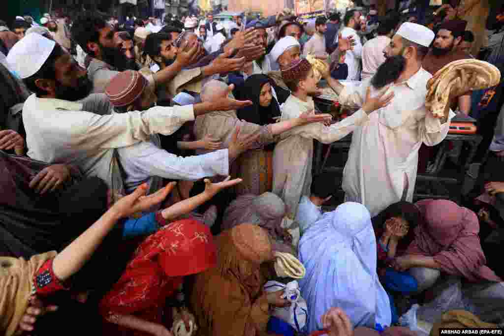 Людзі атрымліваюць бясплатнае харчаваньне падчас мусульманскага посту Рамадан у Пэшавары, Пакістан.