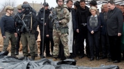 European Commission President Ursula von der Leyen, foreign policy chief Josep Borrell (second from right), and Slovak Prime Minister Eduard Heger (fourth from right) stand next to bodies that were exhumed from a mass grave as they visited the town of Bucha on April 8.