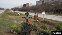 Morminte pe marginea unei străzi din Mariupol, 10 aprilie 2022