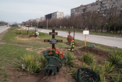 Morminte săpate în spațiul verde dintre două drumuri, în orașul asediat Mariupol, 10 aprilie 2022.