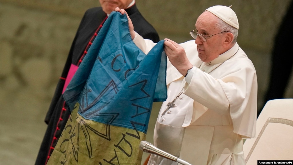 Pope Francis holds up a flag from Bucha during his weekly general audience at the Vatican on April 6.