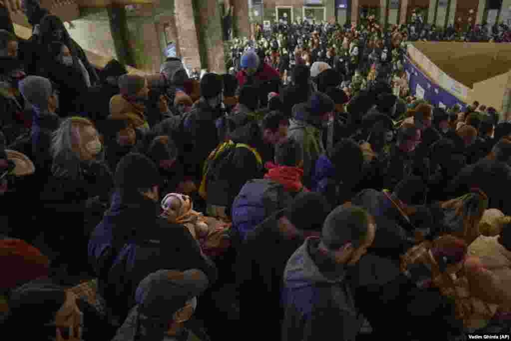Egy férfi viszi csecsemőjét a kezében a tömegben, miközben próbál átkelni egy másik peronra a kijevi vasútállomáson, ahol az utolsó pillanatban mondták be, hogy másik vágányról indul a Lvivbe tartó vonat február 28-án