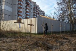 Un cimitir improvizat în apropiere de câteva blocuri din orașul Bucea, Ucraina, 4 aprilie 2022.