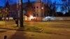 A car is seen on fire after crashing into the fence surrounding the Russian Embassy in Bucharest.