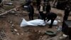 Cadavre ale civililor exhumate de poliție în localitatea Buzova, regiunea Kiev, 10 aprilie 2022. 