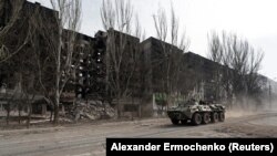 Российская военная техника на фоне разрушенного дома в Мариуполе