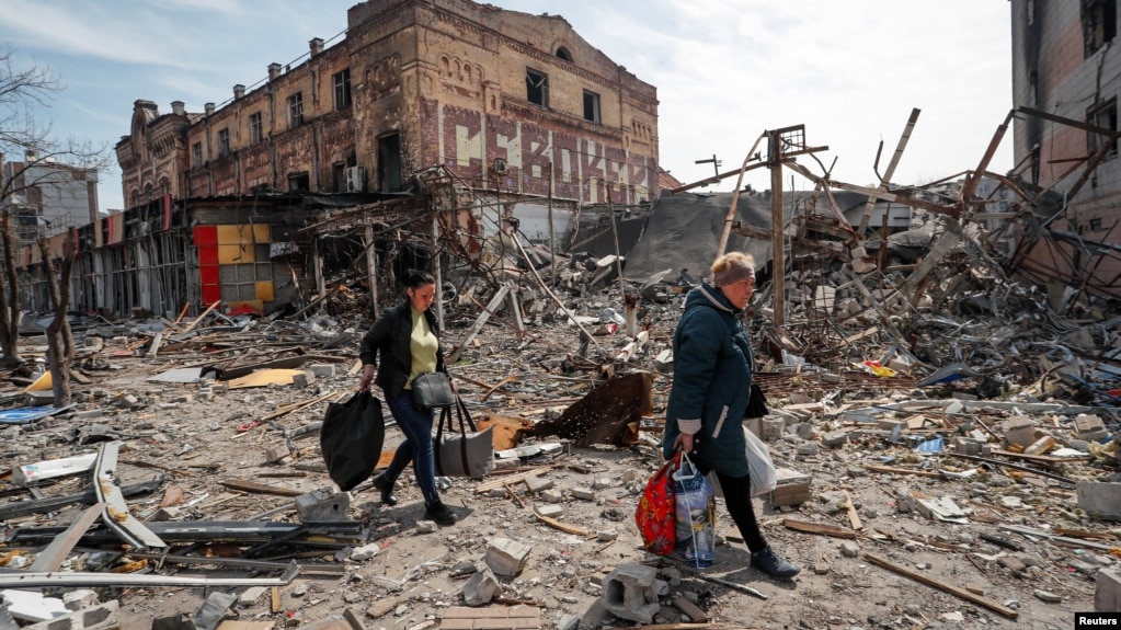 Residents of the besieged port of Mariupol carry their belongings through the city's ruined streets on April 10.