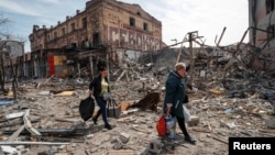 Residents of the besieged port of Mariupol carry their belongings through the city's ruined streets on April 10. 
