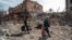 Residents of the besieged port of Mariupol carry their belongings through the city's ruined streets on April 10. 