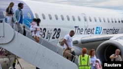Avion muntenegrean cu inscripția „Următorul membru UE”. Mica țară de la Adriatică este aproape gata cu „temele de casă”, dar tot se teme de o eventuală amânare.