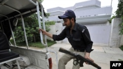 A Pakistani policeman in front of the locked residence of Faisal Shahzad near Peshawar